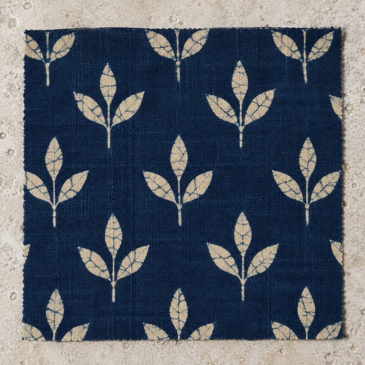 Finished indigo cotton batik with cream sprigs crossed by fine indigo crackle lines