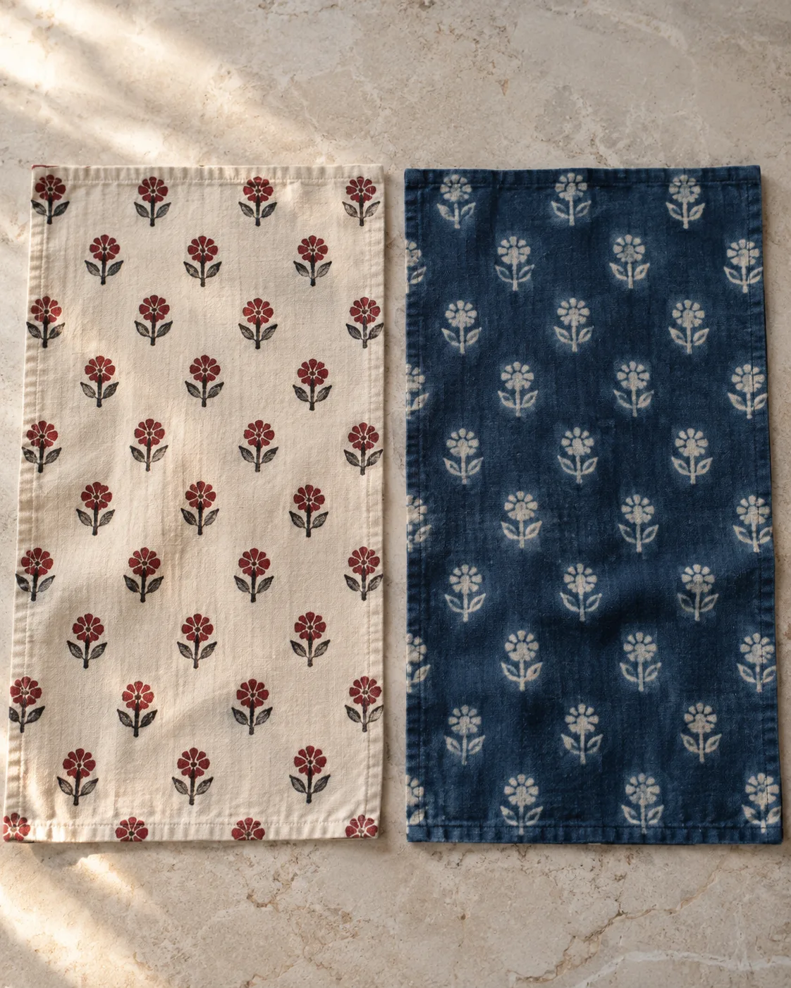 Floral cotton swatches: red and black flowers on cream at left, pale flowers on indigo at right