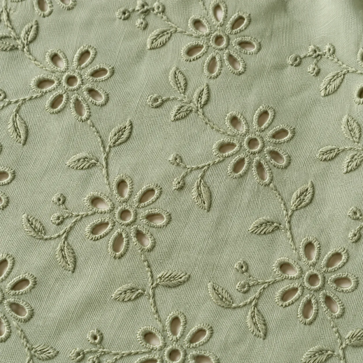 Mint woven cotton with tonal floral embroidery and round and oval eyelet openings