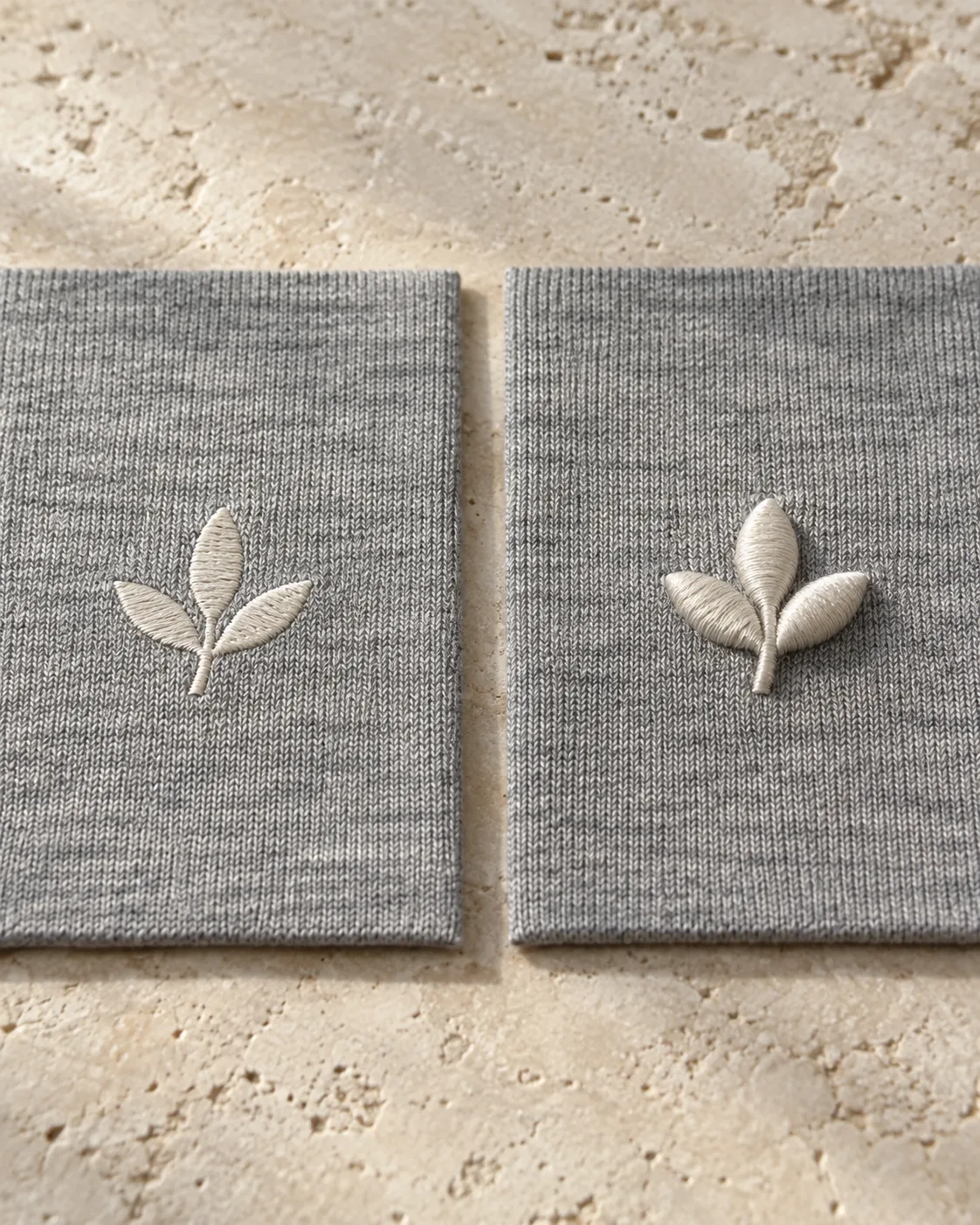Off-white three-leaf motifs on grey knit: flat satin embroidery on the left and raised puff embroidery on the right