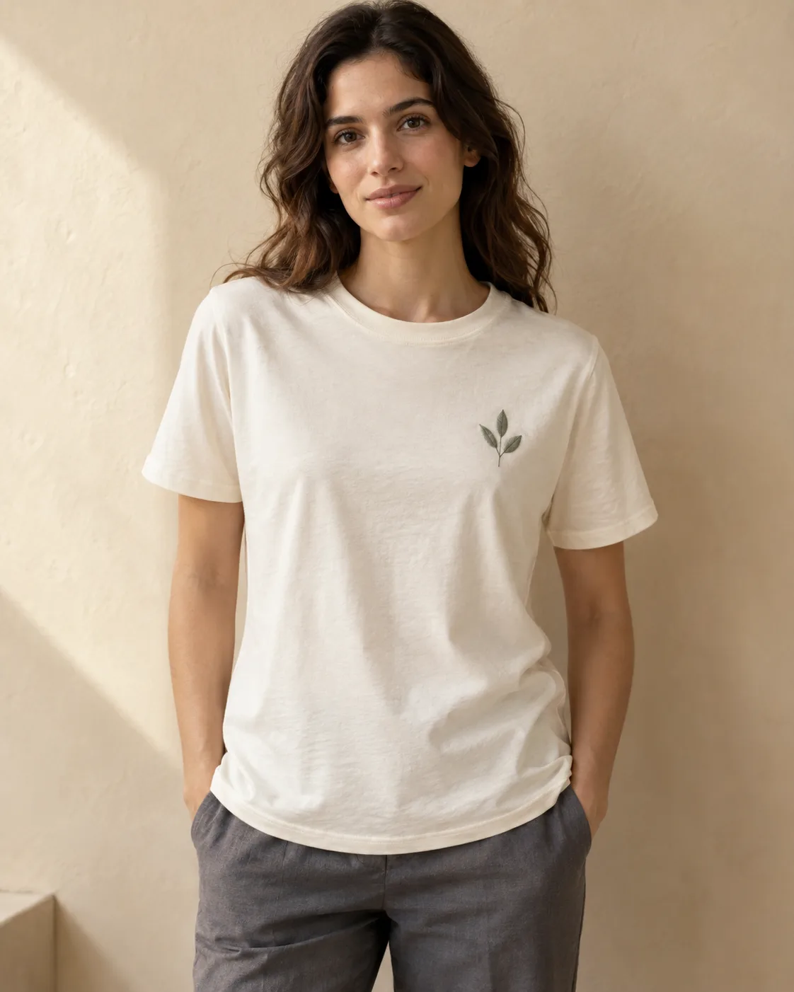 Ecru jersey T-shirt with a grey-sage three-leaf motif embroidered at left chest