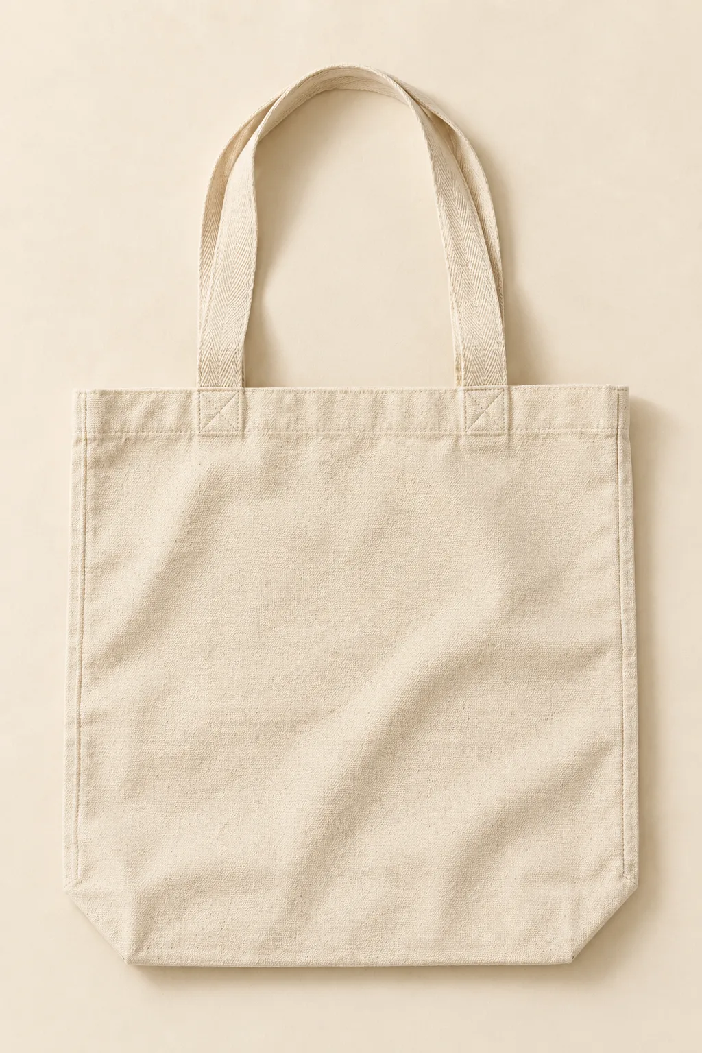 Natural cotton canvas tote bag with woven handles, laid flat