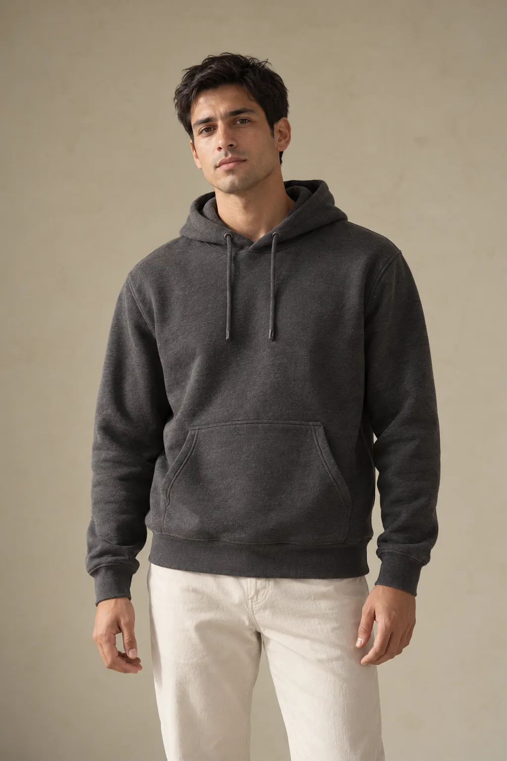 Man wearing a charcoal pullover hoodie with a kangaroo pocket