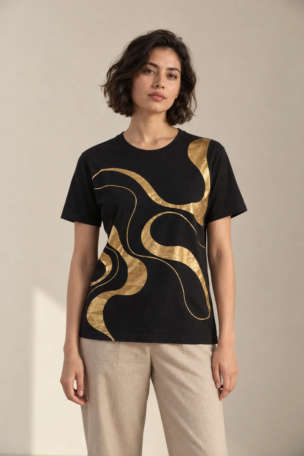 Black T-shirt with an abstract gold foil print across the front