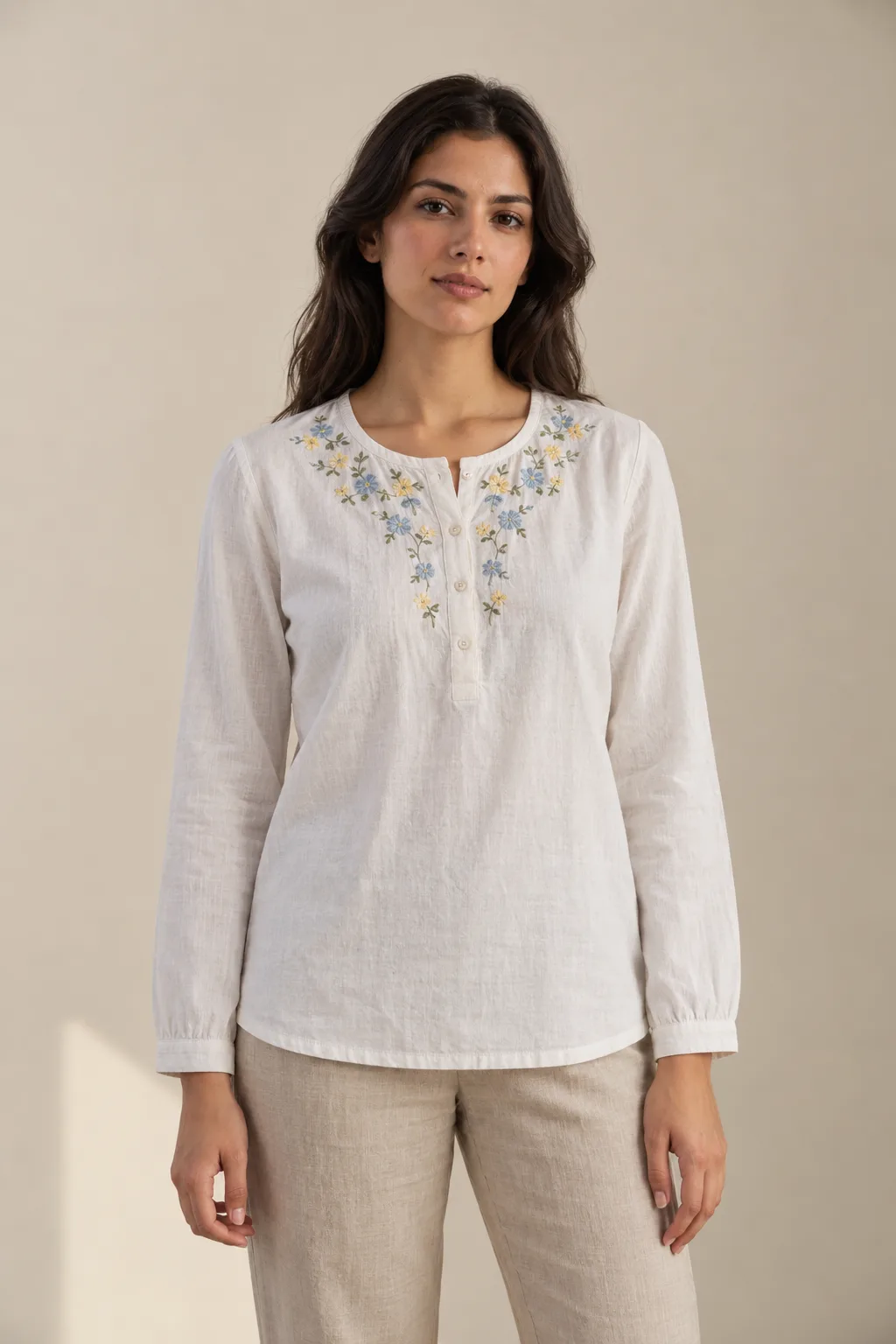 White cotton blouse with blue and yellow flowers embroidered around the neckline
