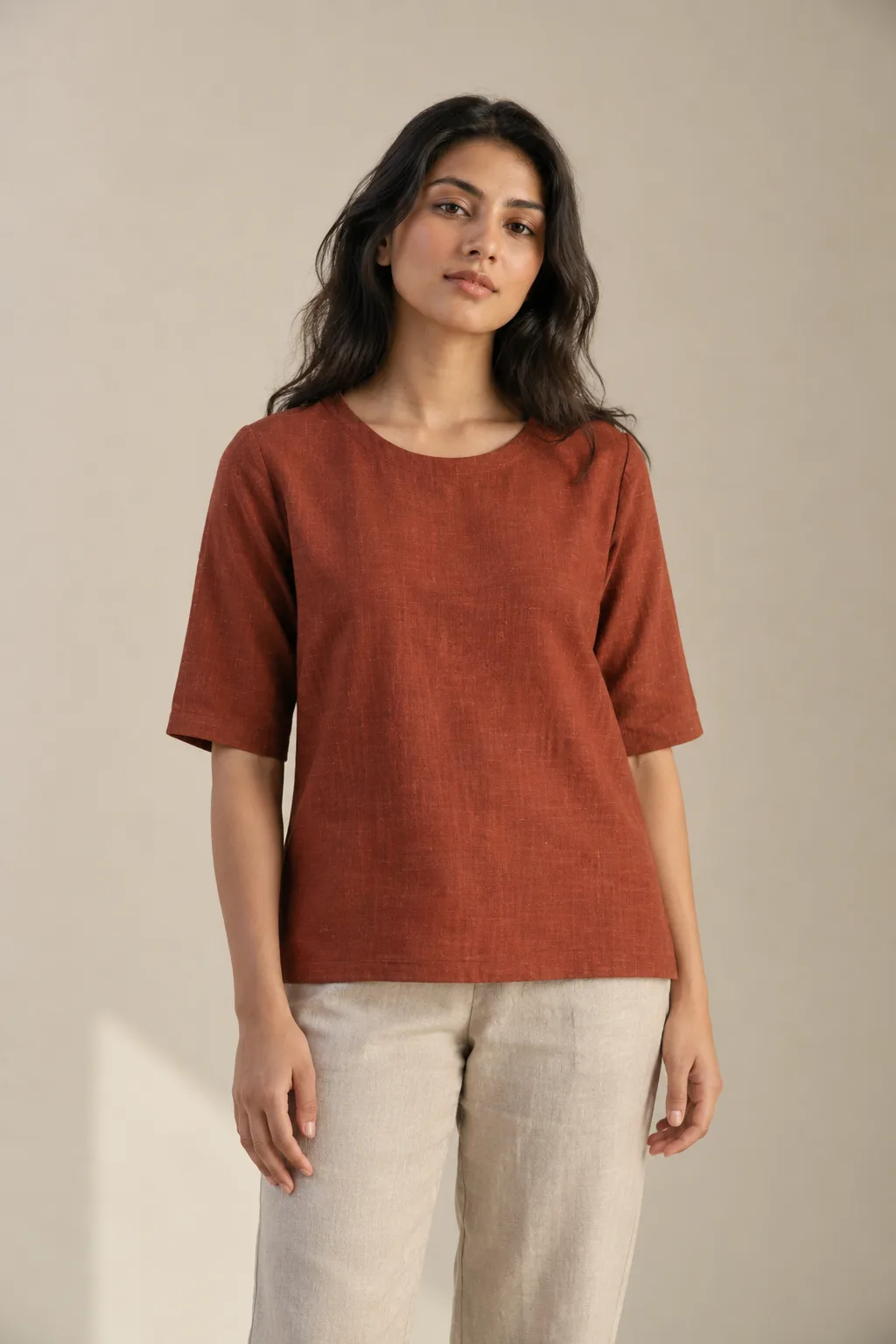 Rust top with elbow-length sleeves and a round neckline