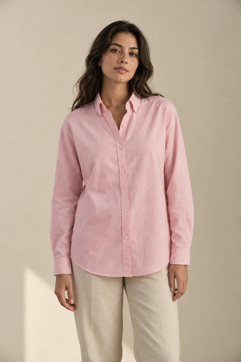 Woman wearing a relaxed pink Oxford shirt