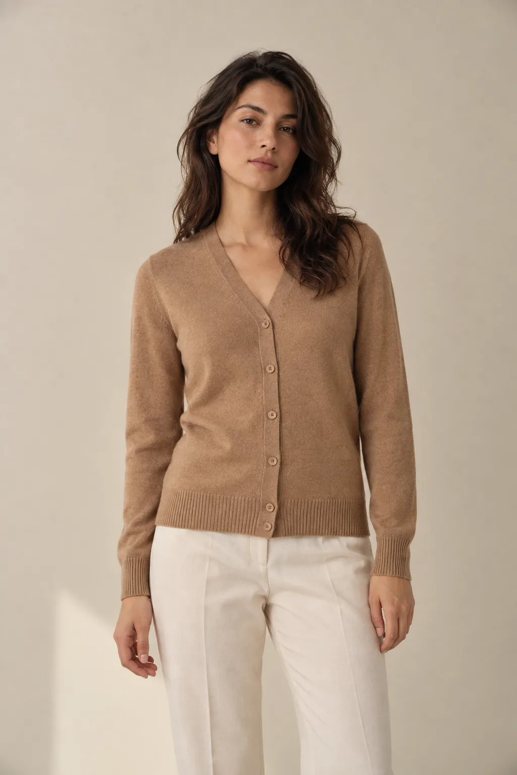 Woman wearing a camel V-neck cardigan with buttons