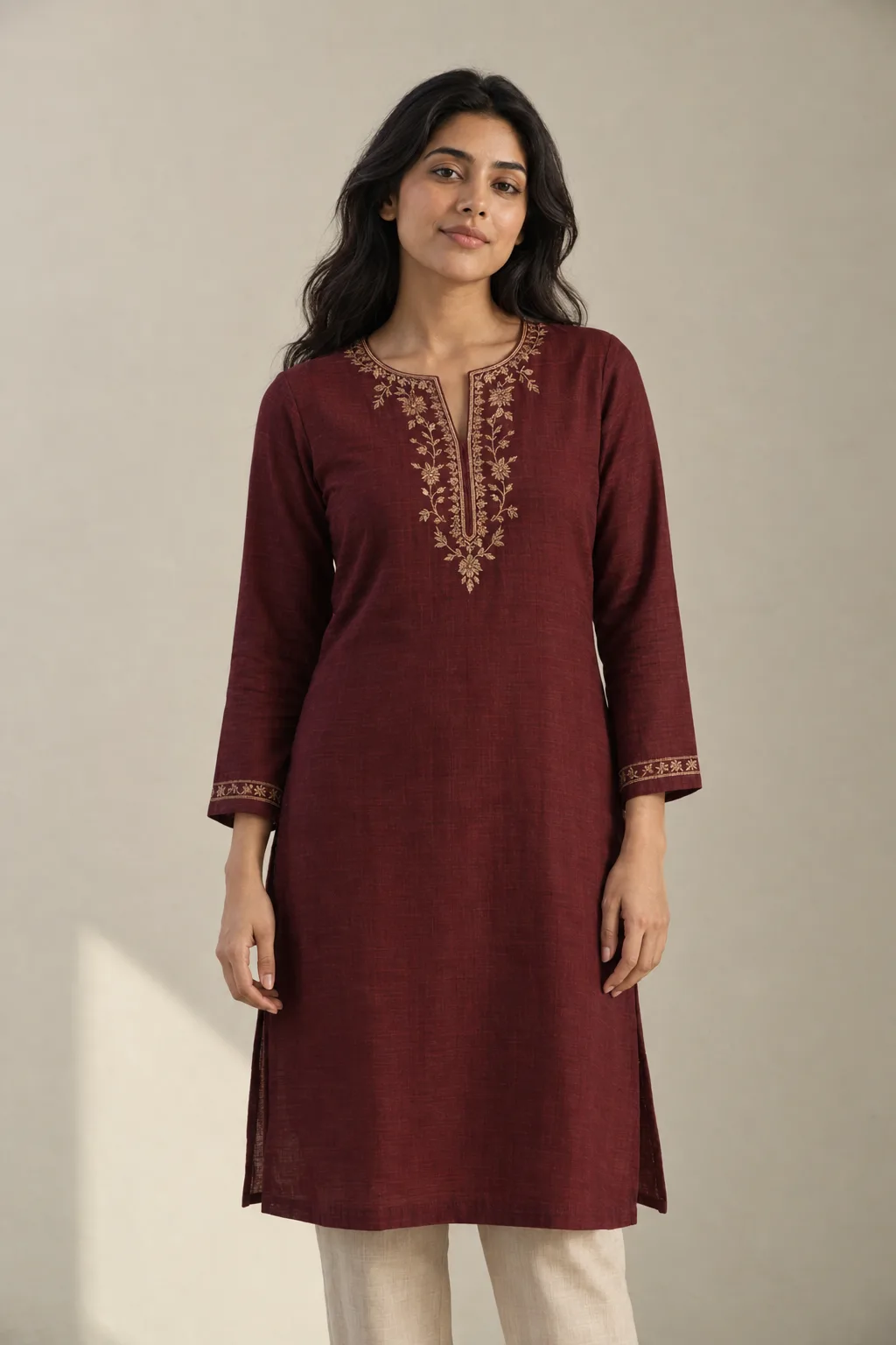 Maroon kurta with gold-coloured floral embroidery around the neckline and cuffs