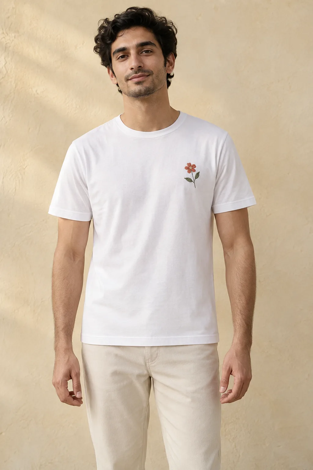 White cotton jersey crew-neck T-shirt with a small terracotta flower and sage leaves at the chest