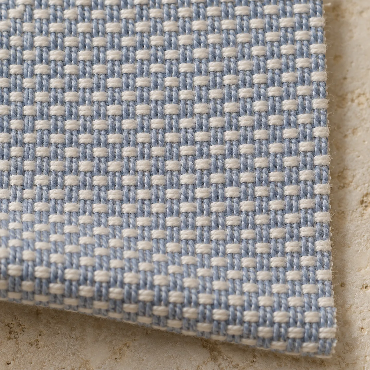 Close-up of blue warp yarns woven in pairs across single white weft yarns