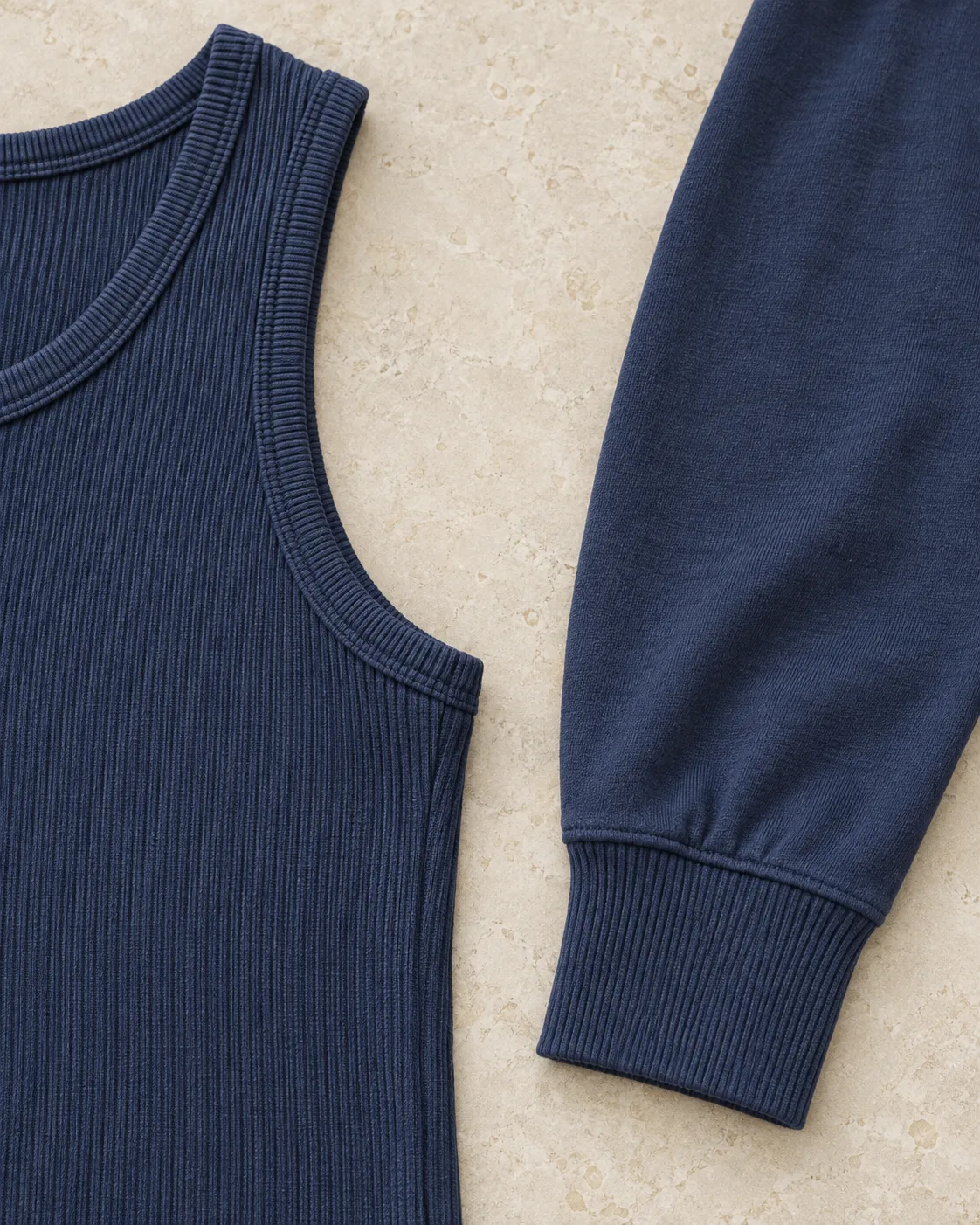 Indigo rib-knit sleeveless top beside a smooth jersey sleeve with an attached rib cuff