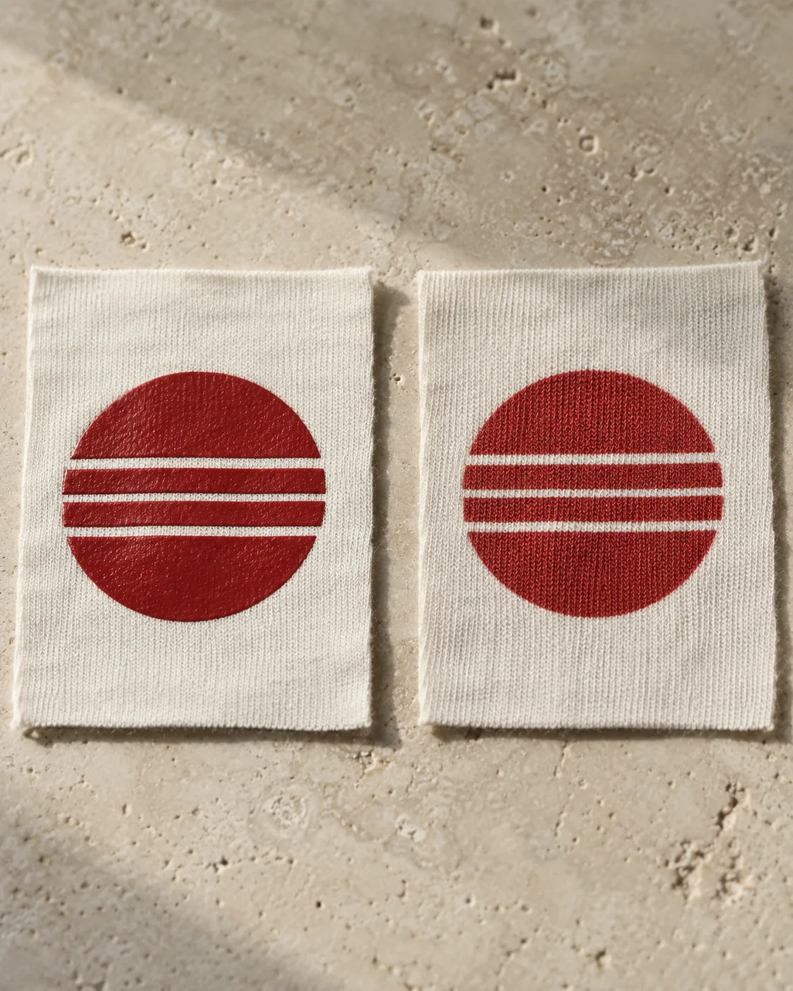 Two off-white jersey pieces with matching brick-red banded-circle prints, with a raised film on the left and more knit texture on the right