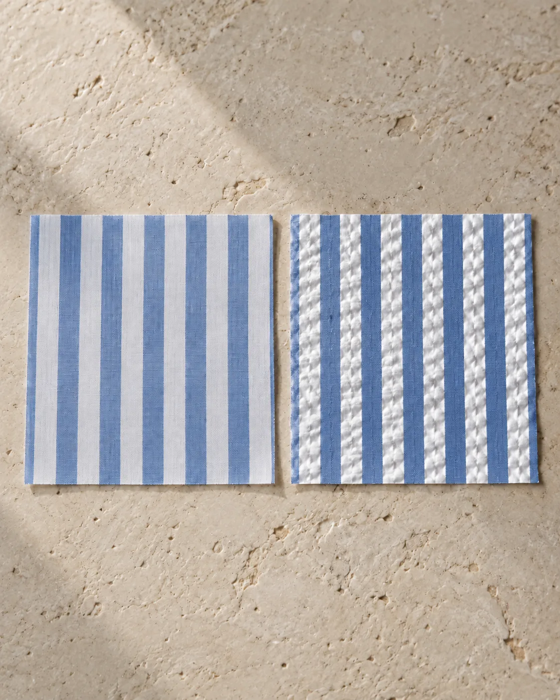 Two blue and white striped cotton swatches: flat poplin on the left, seersucker with puckered white stripes on the right