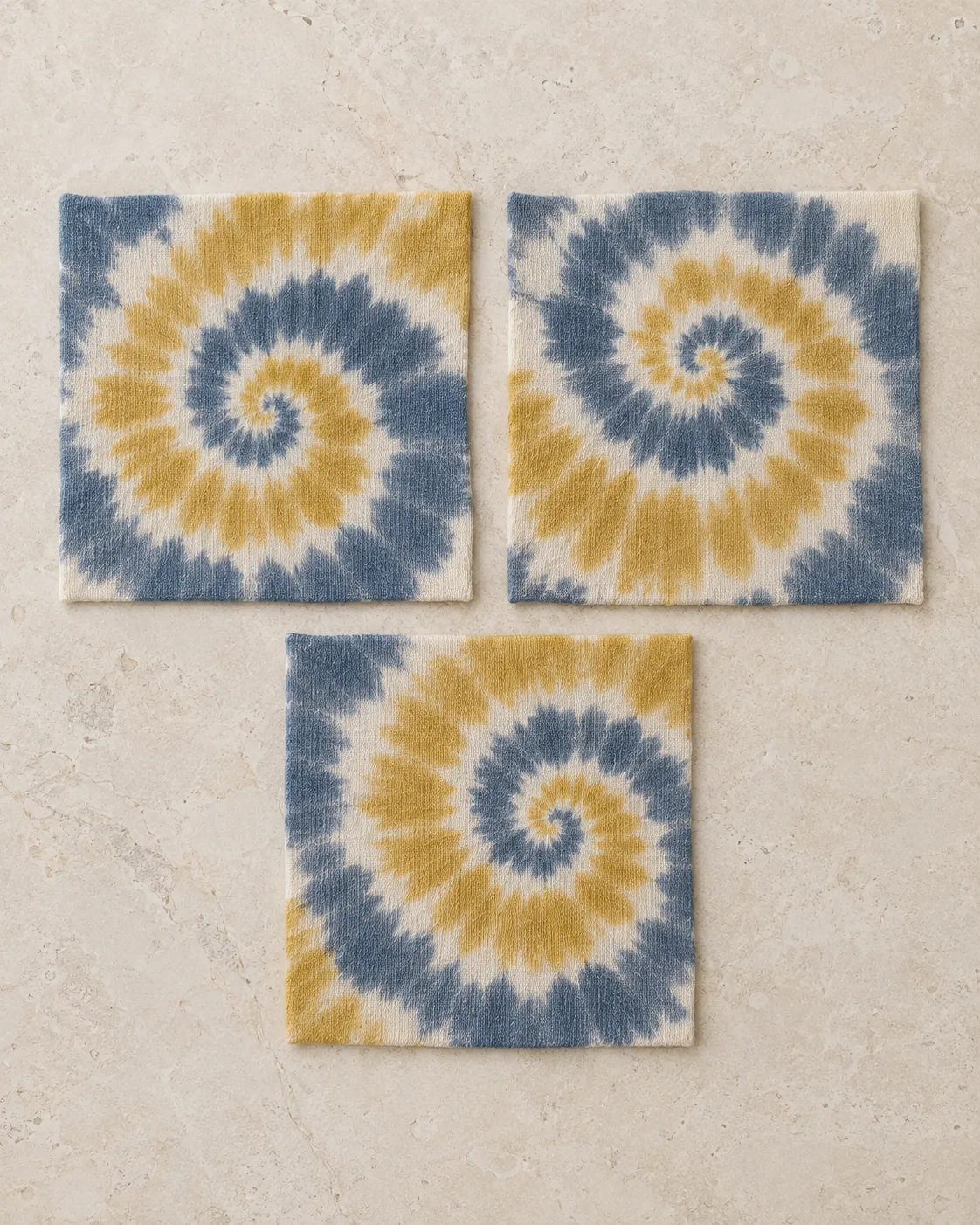 Three spiral tie-dye jersey squares in slate-blue, mustard and ecru with different colour coverage and spiral positions